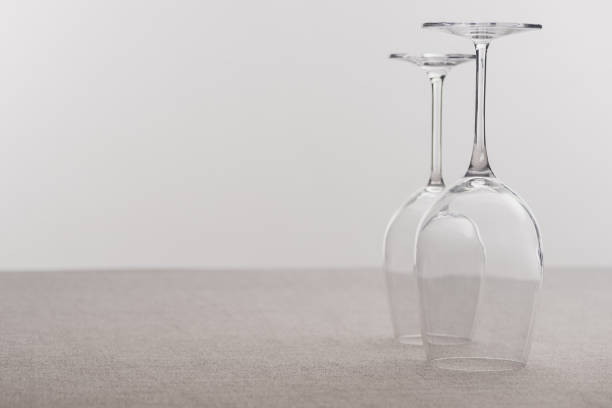 Inverted wine glasses on tablecloth isolated on grey