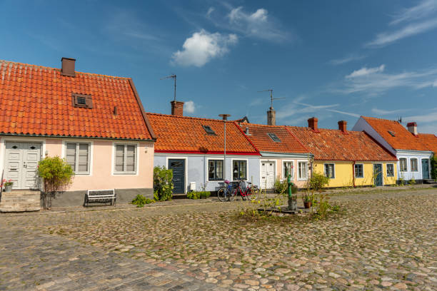 Simrishamn, Sweden, 06-08-2019.\nBeautiful cobblestone street in Simrishamn in the south east part of Sweden, called Österlen. With small picturesque colorful houses along the narrow street. In summer sunlight and a blue sky