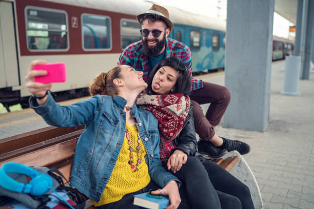 istock Happy friends making selfies at the train station platform 1198611566