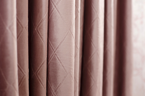 powder pink rose curtains with soft folds - horizontal close up photo with selective focus. Perfect background
