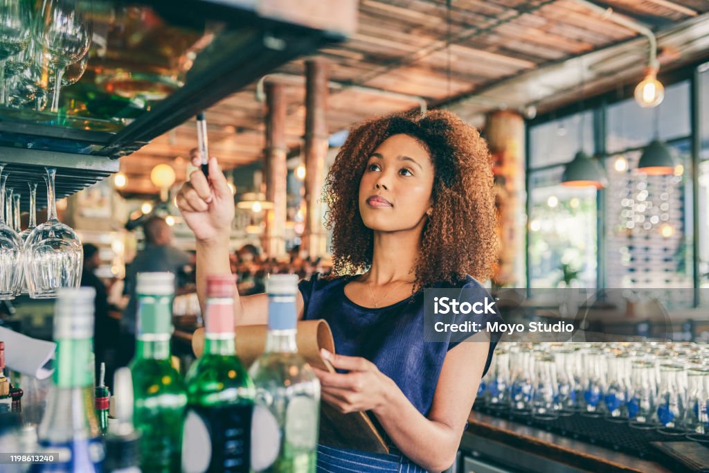 Managing my own business  gets a bit easier every day Cropped shot of a young woman counting stock in a bar Restaurant Stock Photo