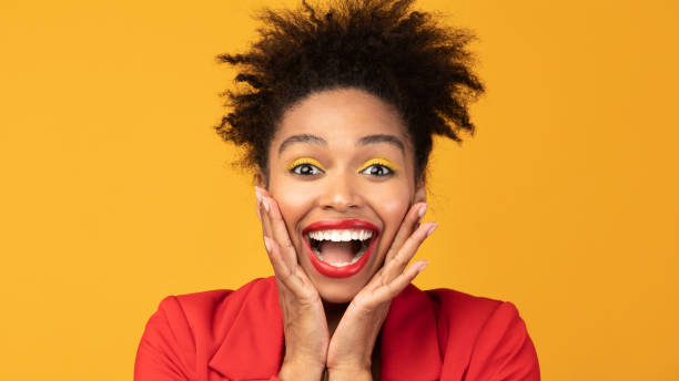 istock Happy afro woman screaming and holding cheeks 1198614763