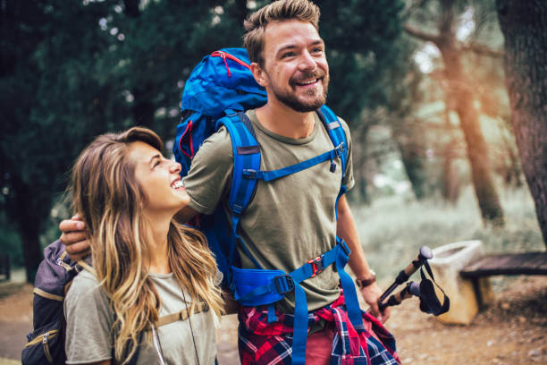 istock Smiling couple walking with backpacks over natural background 1198614944