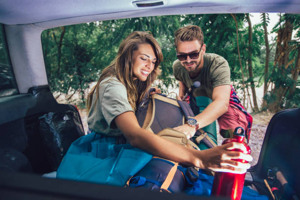 istock Young couple is having fun while unpacking camping equipment 1198614954