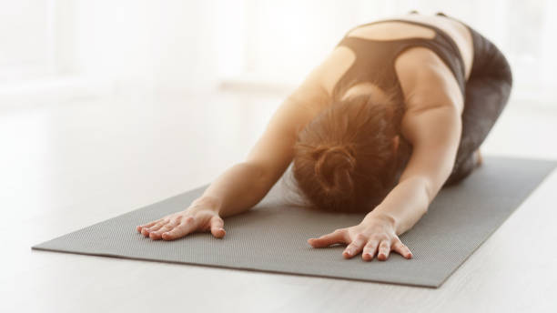 istock Woman practicing yoga, stretching in Child exercise 1198615339