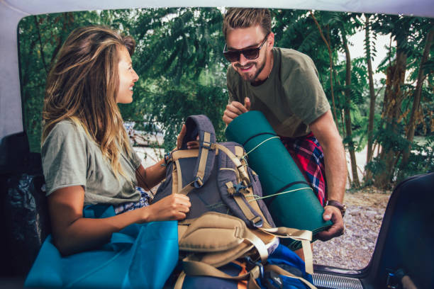 istock Young couple is having fun while unpacking camping equipment 1198615426