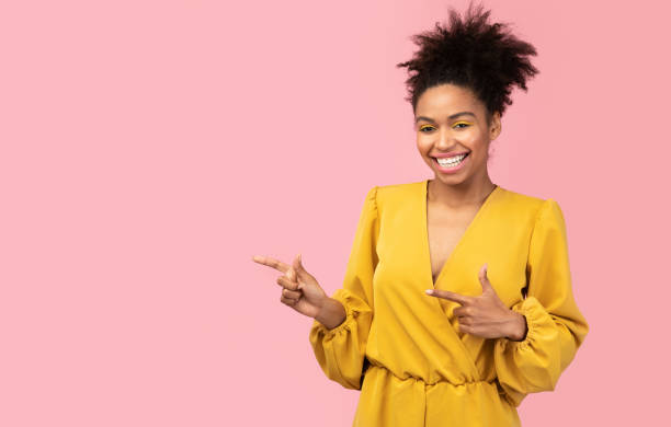 istock Smiling black girl pointing fingers at free space 1198615652