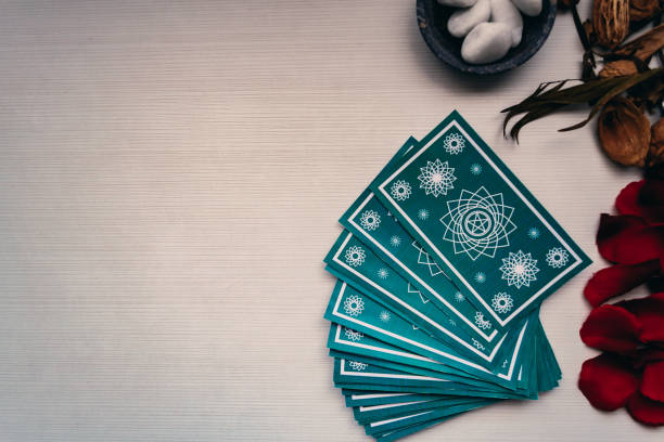 istock Green tarot cards with different mystical objects on white wood. Space for texts 1198616258