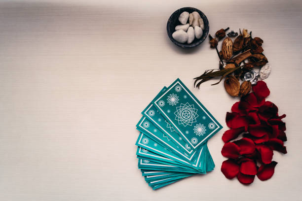 istock Green tarot cards with different mystical objects on white wood. Space for texts 1198616259