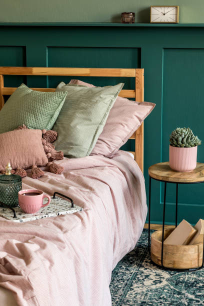 istock Stylish bedroom interior with design coffee table, plant, book, shelf and elegant personal accessories. Beautiful bed sheets, blanket and pillow. Template. Modern home staging. Wall panelling. 1198616694