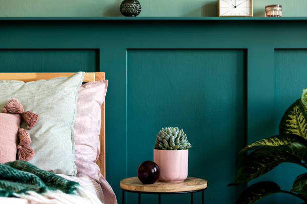 istock Modern bedroom interior with design coffee table, succulent, plant and elegant personal accessories. Beautiful bed sheets, blanket and pillows. Template. Stylish home staging. Wall panelling. Details 1198616999