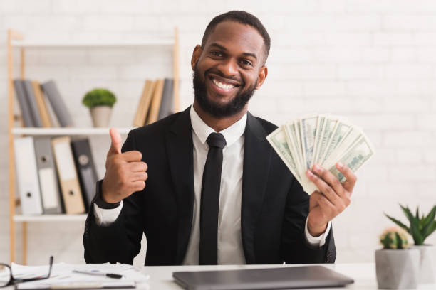 sorridente uomo d'affari nero di successo che detiene un sacco di soldi - excitement business person ecstatic passion foto e immagini stock