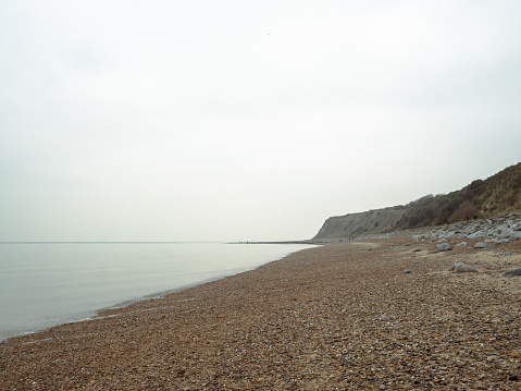 Pebbled beach on the Kent coast near Reculver Towers on cloudy New Year's day