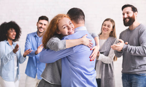 istock Positive people hugging each other at rehab group meeting 1198617537