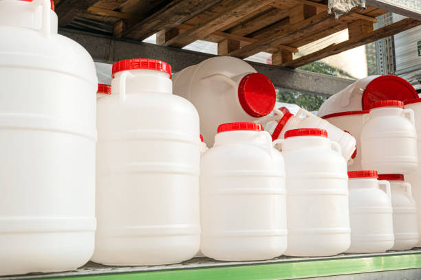 istock White plastic cans with red lids on a rack stillage. Domestic tanks for drinking water. 1198618819