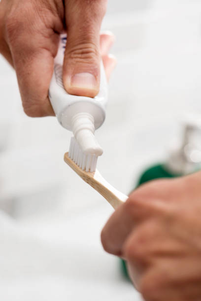istock man using a bamboo toothbrush in the bathroom 1198620361