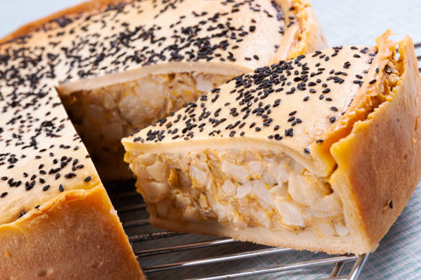 Sliced palm heart chicken salty pie Sliced palm heart chicken salty pie with a crispy golden-brown crust and black sesame, ready to eat, on a blue napkin palm heart photos stock pictures, royalty-free photos & images