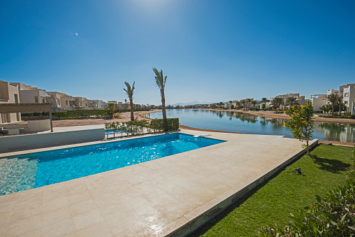 Luxury villa show home in tropical summer holiday resort with swimming pool and lagoon view