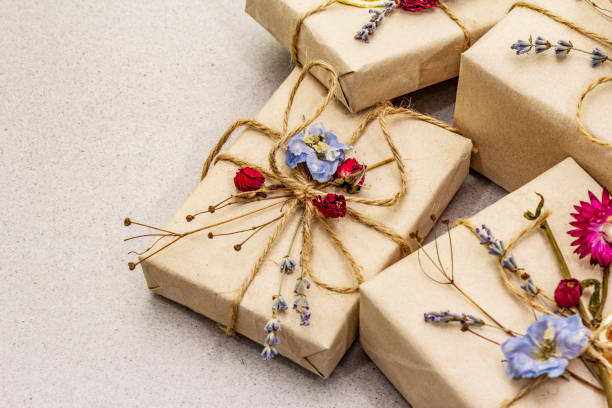 istock Zero waste gift concept. Valentine Day or Birthday eco friendly packaging. Festive boxes in craft paper with different organic decorations. Stone concrete background 1198621557