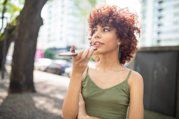 istock Latina sending voice message on cellphone outdoor 1198622440