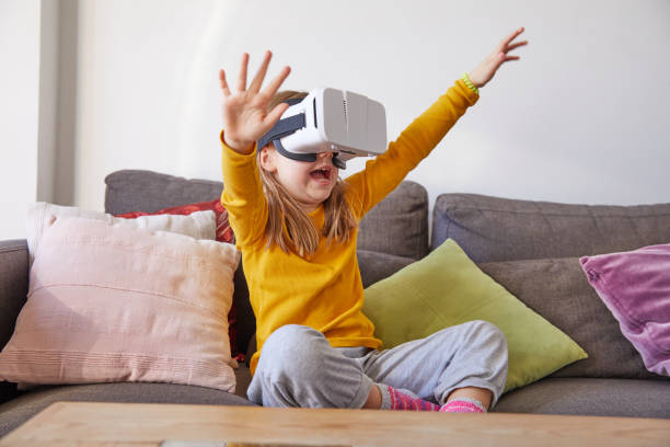 istock child watching virtual reality glasses shouting with arms up 1198624387