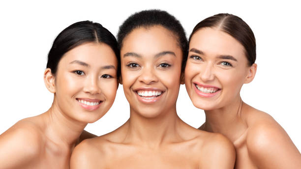 Three Multiracial Models Posing Smiling On White Studio Background, Panorama Three Multiracial Models Girls Posing Smiling At Camera Standing On White Studio Background. Skin And Body Care Beauty Concept. Panorama semi dress stock pictures, royalty-free photos & images