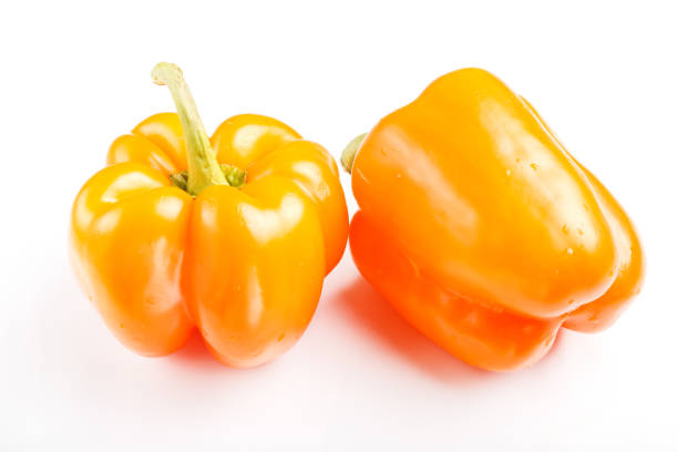 Two Vibrant Orange Bell Peppers on White cut out