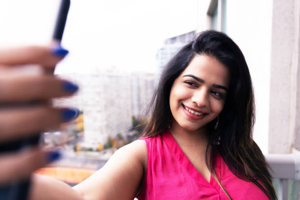istock Girl taking selfie using a smartphone at the apartment balcony 1198629487