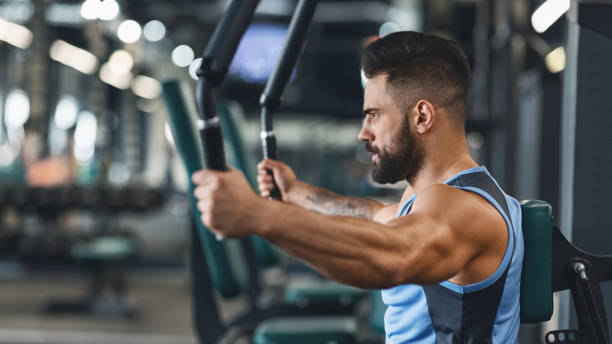 istock Young bodybuilder exercising on training apparatus at gym 1198630000
