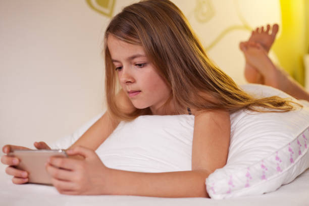istock Young girl using her smartphone lying in bed, shallow depth 1198630180