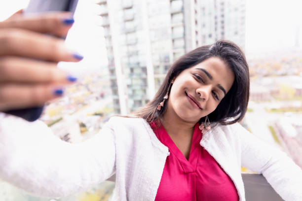 istock Girl taking selfie using a smartphone at the apartment balcony 1198630323