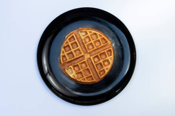 istock Top view of a waffle served in a black plate isolated on white background 1198632998
