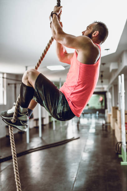istock Male Athlete Demonstrating Rope Climbing Techniques In Gym 1198635121