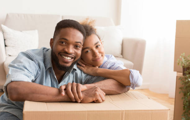 istock Happy Couple Hugging Sitting Among Unpacked Boxes In New Home 1198635151