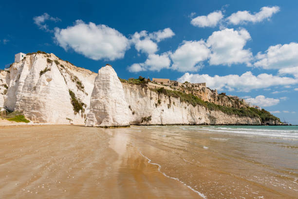 Limestone rock monolith and cliffs by the beach, Vieste, Gargano, Apulia, Italy.