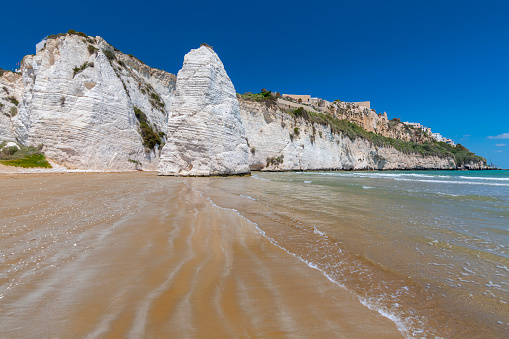 Limestone rock monolith and cliffs by the beach, Vieste, Gargano, Apulia, Italy.