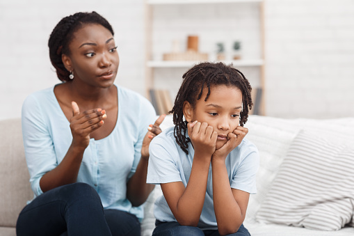 Family Conflict. Quarrel between black mother and daughter at home, sulky child ignoring her mom, copy space