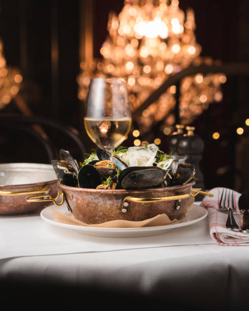 Moules frites served in a copper pan on a white tablecloth