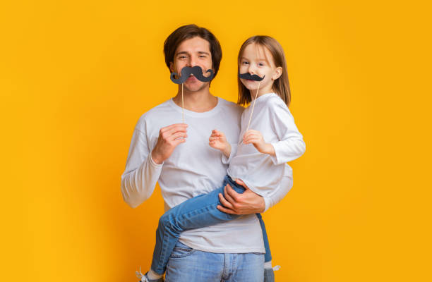 istock Funny girl and dad have mustaches on sticks 1198638980