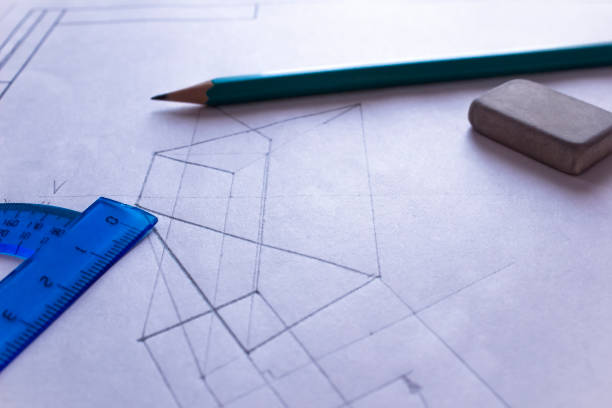 istock A protractor, pencil, and eraser lie on white paper with a drawn drawing. Drawn diagram on a large sheet with stationery 1198638983