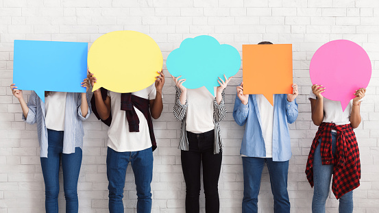 Everyone has own opinion. Teens holding empty colourful speech bubbles