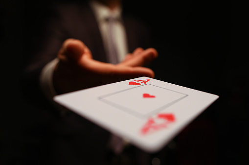 Empresario en traje lanza su mano jugando as de cartas photo