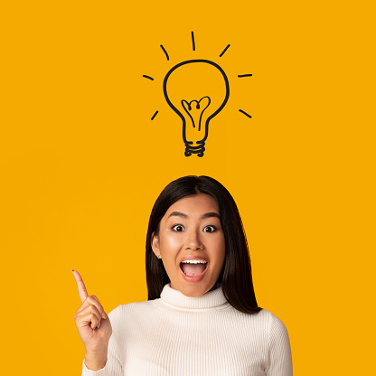 Brainstorming concept. Idea lamp glowing above girl head, yellow background, crop