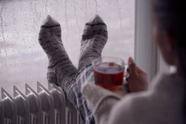sur l'image d'épaule d'une femme buvant le thé à la maison par temps froid et humide. - knitting residential structure glasses hot drink photos et images de collection