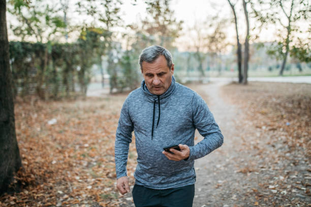 istock Jogging in a public park using a mobile phone 1198643500
