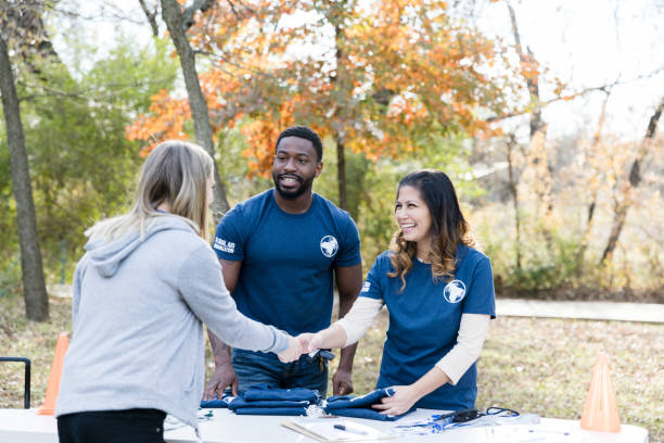 istock Friendly volunteer greets woman during charity event 1198645558