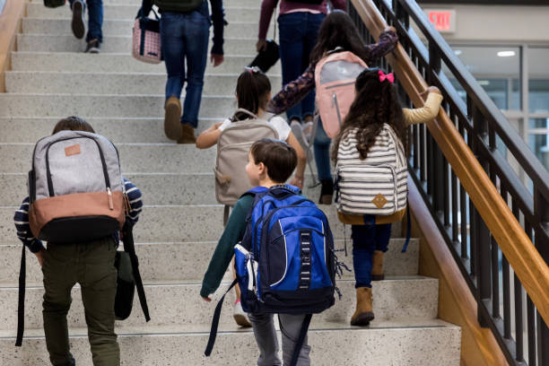 istock Students with backpacks climb main staircase first day of school 1198645814