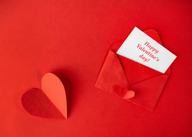 istock Red paper envelope with a Valentine's day card on a red background with a heart 1198646741