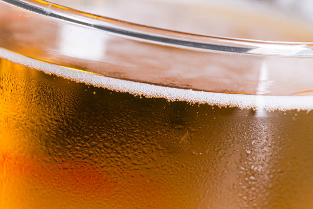 istock White froth on a blond beer served on a glass macro still 1198647584