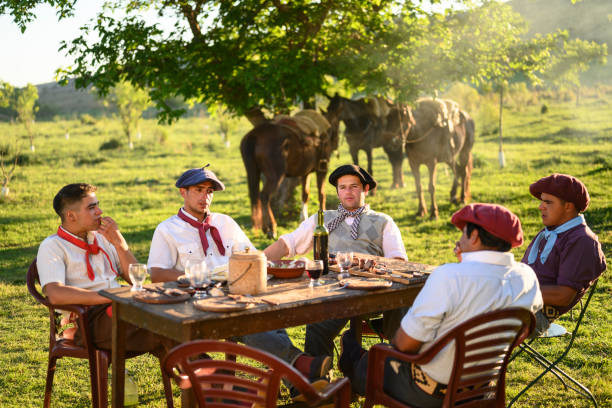 istock Gauchos sitting at outdoor table and talking after asado 1198650256